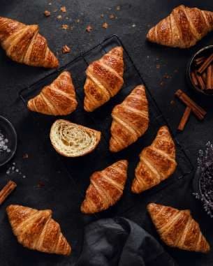 AI render: croissants scattered on a dark surface with cinnamon