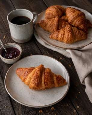 AI render: croissant with black coffee and jam on a dark wooden table